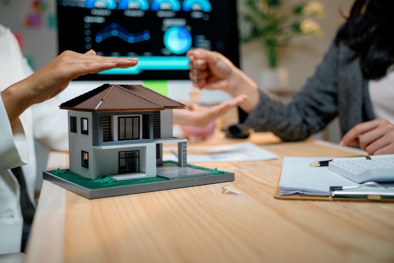 real estate agent protecting house model and giving keys to client.jpg